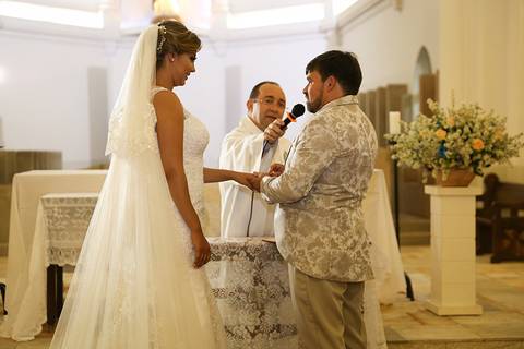 Noivo coloca a aliança no noiva, enquanto diz o SIM'