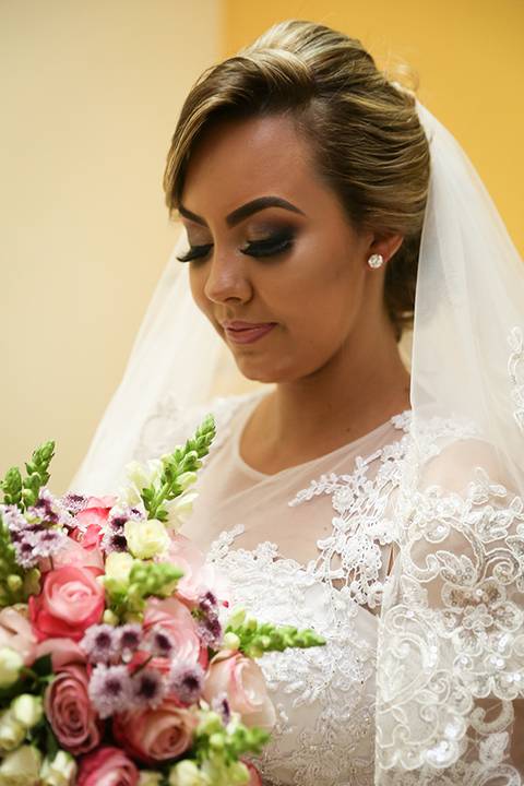 Noiva posa, pronta, antes de sair para igreja com o  bouquet'