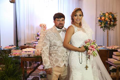 Noivos posam na decoração'