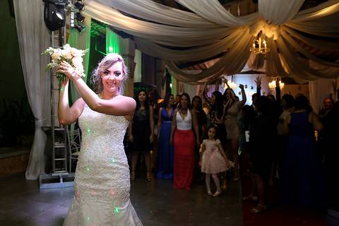 Noiva, sorridente, se prepara para jogar o bouquet'