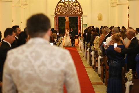 Noivo, de costas, observa a grande entrada da noiva na igreja'
