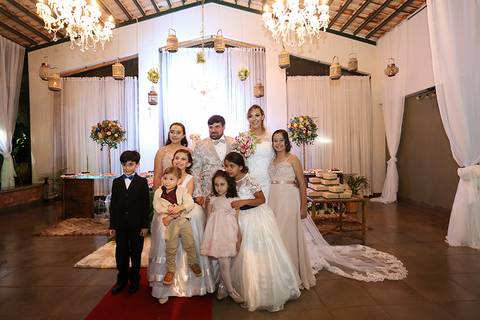 Noivos, damas e pagem posam mesa do bolo, após a cerimonia'