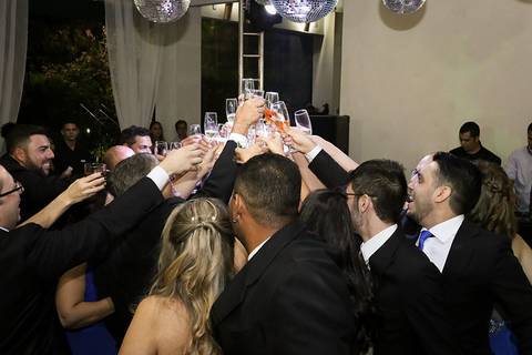 Brinde dos noivos com padrinhos, todos levantam as taças'