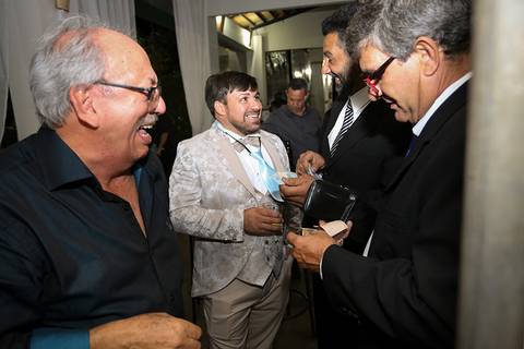 Noivo se diverte com amigos durante o corte da gravata'