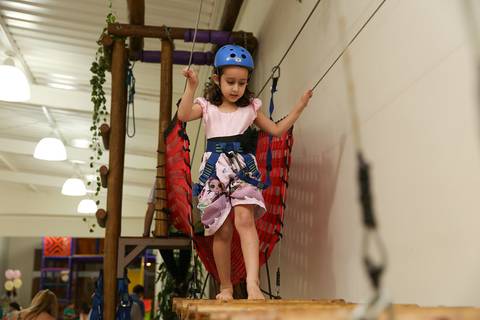 Convidada aventureira brinca na tirolesa do salão de festas Salamê Mingueê'