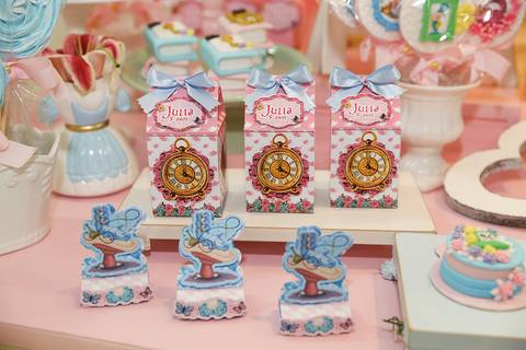 Detalhes na mesa do bolo, caixinhas vasinhos e doces, tudo em tema Alice no País '