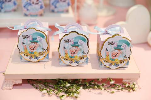Detalhes na mesa do bolo, caixinhas com detalhes do Chapeleiro Maluco, tudo em tema Alice no País '