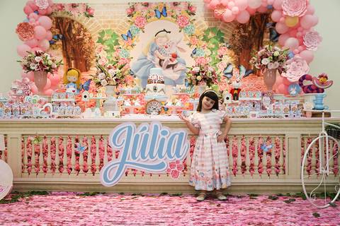 Aniversariante posa na mesa do bolo'