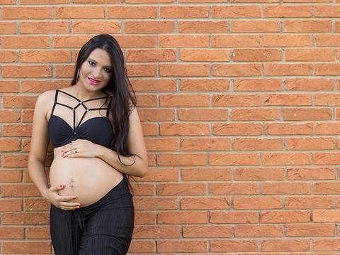 tijolinhos, de roupas pretas, olhando para câmera e acariciando a barriga'