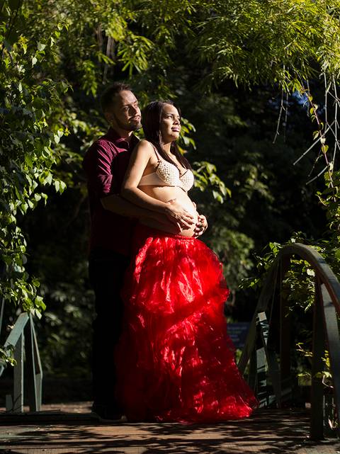 Pais posam na ponte estilo japonês, acariciam a barriga e olham para o horizonte'