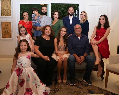A família toda posa na sala, pais, filhos e netos'