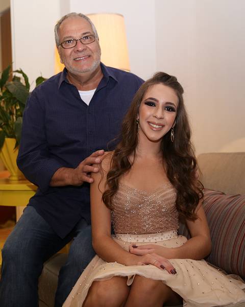 Aniversariante posa com o avô na decoração da sala'