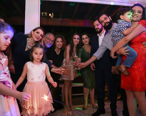 Família brinda a debutante, posando para camera'
