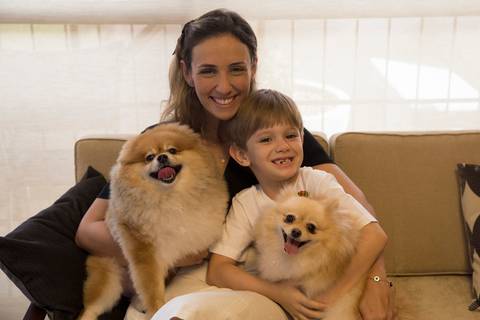 Os dois irmãos Spitz posam com sua mãe e irmão humanos, no sofá de casa'