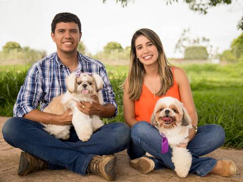 Os dois shih-tzu posam com seus pais humanos no parque'
