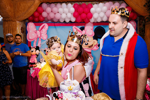 mamãe e papai junto com a aniversariante catharina assoprando a vela do bolo'