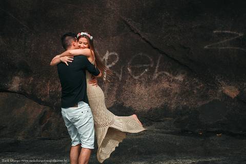 Ensaio dos Noivos em riviera de são lourenço são paulo bertioga ao nascer do sol durante o ensaio pré-wedding na praia no por do sol com pedras montanhas arvores'