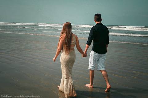 noivos caminhando na Praia em riviera de são lourenço são paulo bertioga ao nascer do sol durante o ensaio pré-wedding na praia no por do sol com pedras montanhas arvores'
