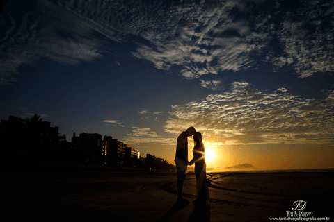 silhueta do casal de noivos em riviera de são lourenço são paulo bertioga ao nascer do sol durante o ensaio pré-wedding na praia no por do sol'