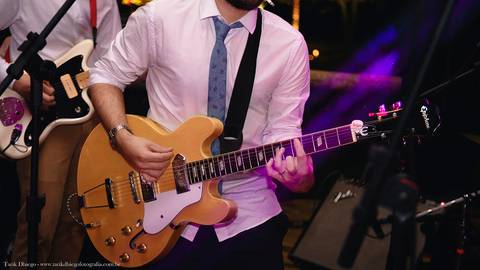 Noivo tocando guitarra no seu casamento durante a Festa na Reserva Tambá na praia de Toque Toque Pequeno em São Sebastião após a cerimônia do casamento na Praia'