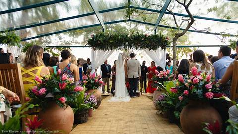 detalhes dos noivos e convidados de costas olhando o mar'