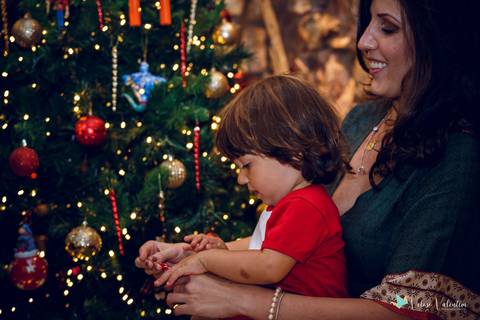 mãe e filho decoram arvore de natal'