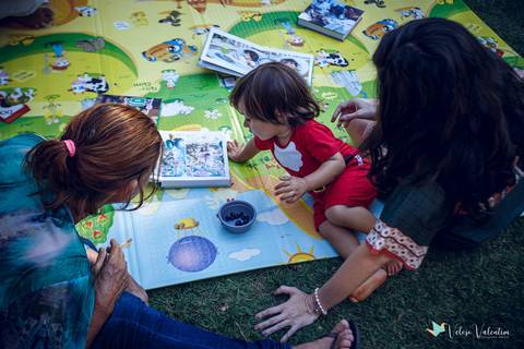 criança no tapete de atividades vendo fotos'