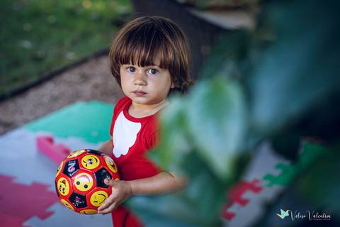 criança segurando bola'