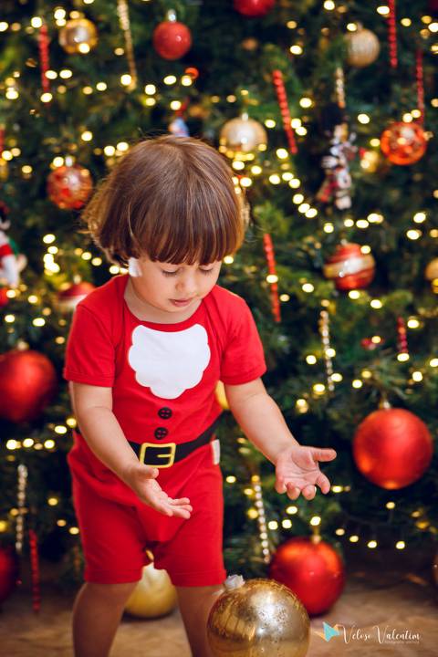 menino brincando com bolas de natal'