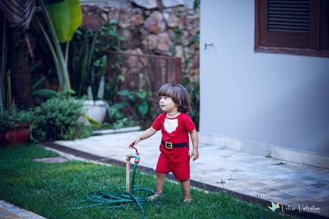 menino ligando a torneira de jardim'