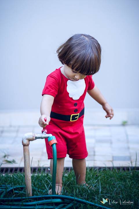 criança abrindo água na mangueira'