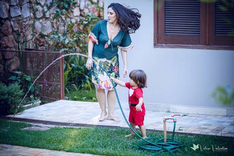 mãe brinca com filho no jardim'