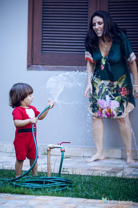 filho molha a mãe com mangueira'