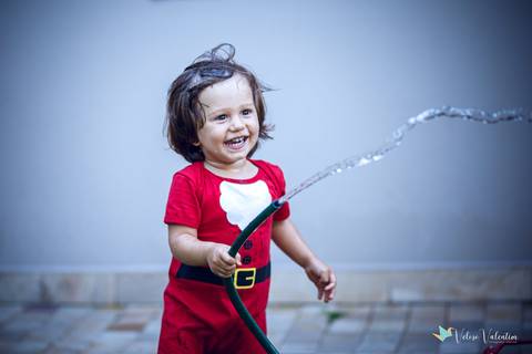 criança molhando o jardim'