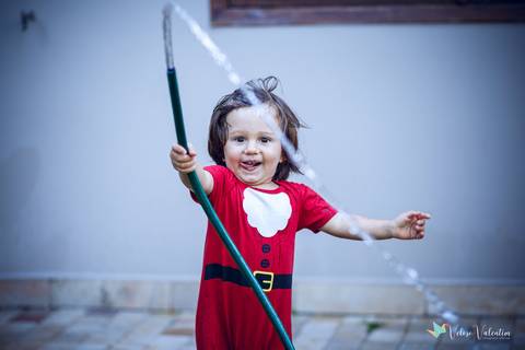 menino brincando com mangueira'