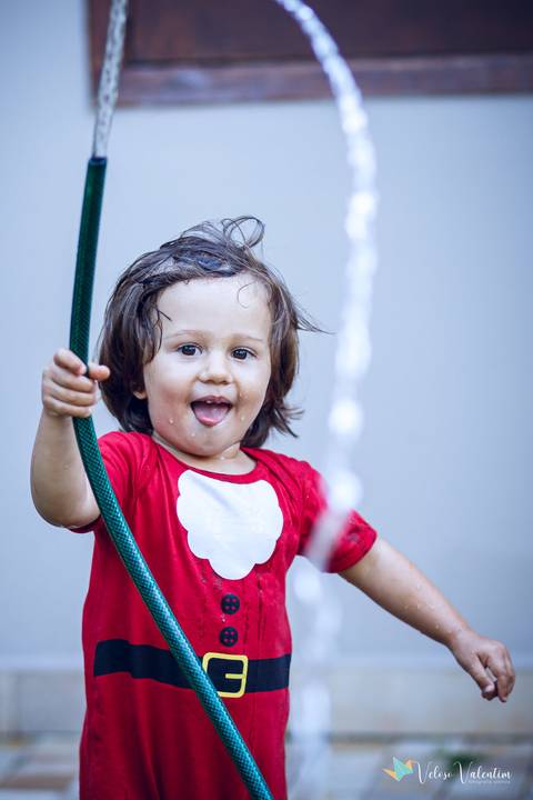 criança brinca com água'