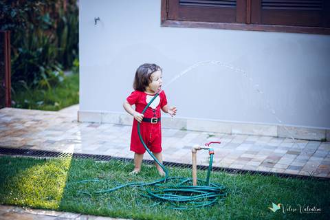 criança tenta beber água da mangueira'