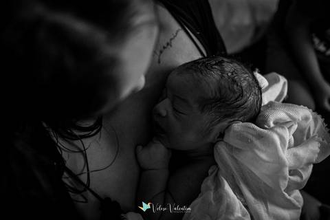 mãe com bebê recém nascido no colo na hora dourada'
