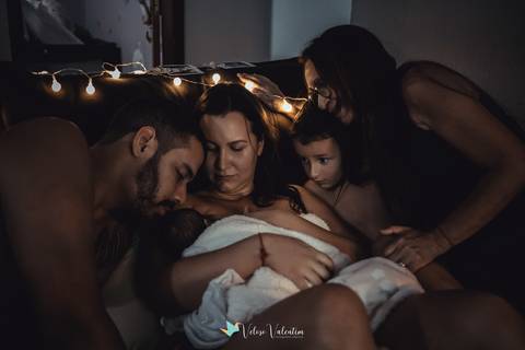 família no sofá com bebê recém nascido'