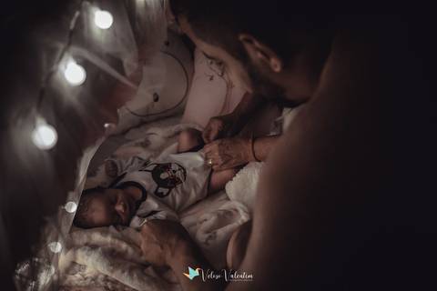 pai olhando a bebê no berço'
