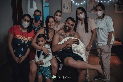 equipe do parto com doula, enfermeiras e fotógrafa posa com a família'