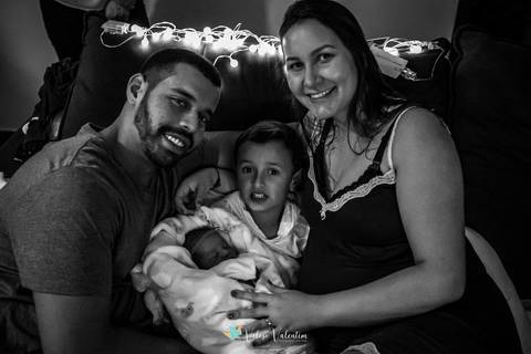 família pai mãe filho filha no sofá'