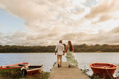 noivo e noiva caminhando no pier em fotografia de casamento'