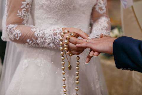 noiva colocando a aliança do noivo'