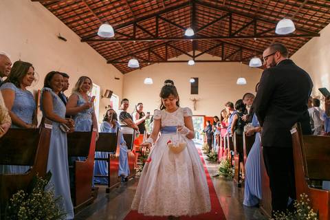 dama entrando na igreja no dia do casamento com as alianças dos noivos '