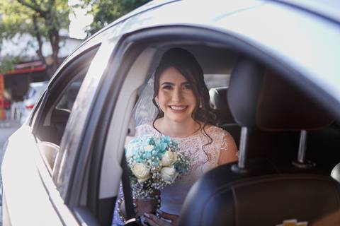 noiva sorrindo dentro do carro ja proximo da entrada da noiva'