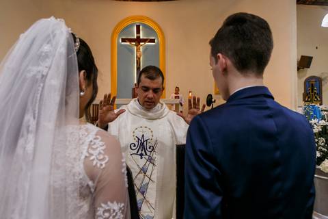 padre impondo as mão no casamento religioso'