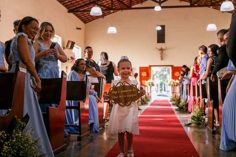 daminha entrando com a placa de entrada da noiva no dia do casamento religioso na igreja do antonio bezerra'