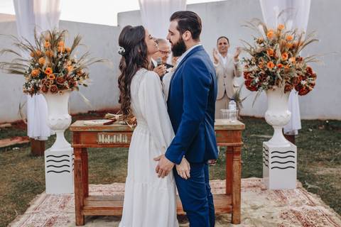 Beijo dos noivos em  cerimonia ao ar livre'