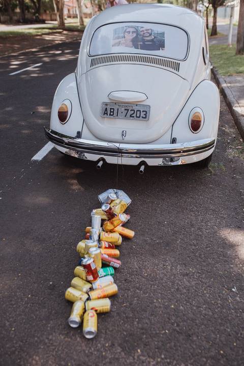 Saida dos noivos para festa em fusca com latinhas estilo vintage'